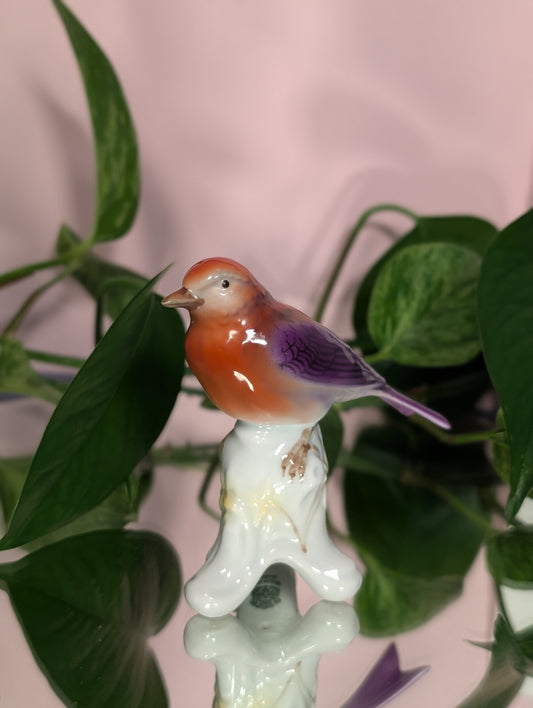 Purple bird figurine on branch